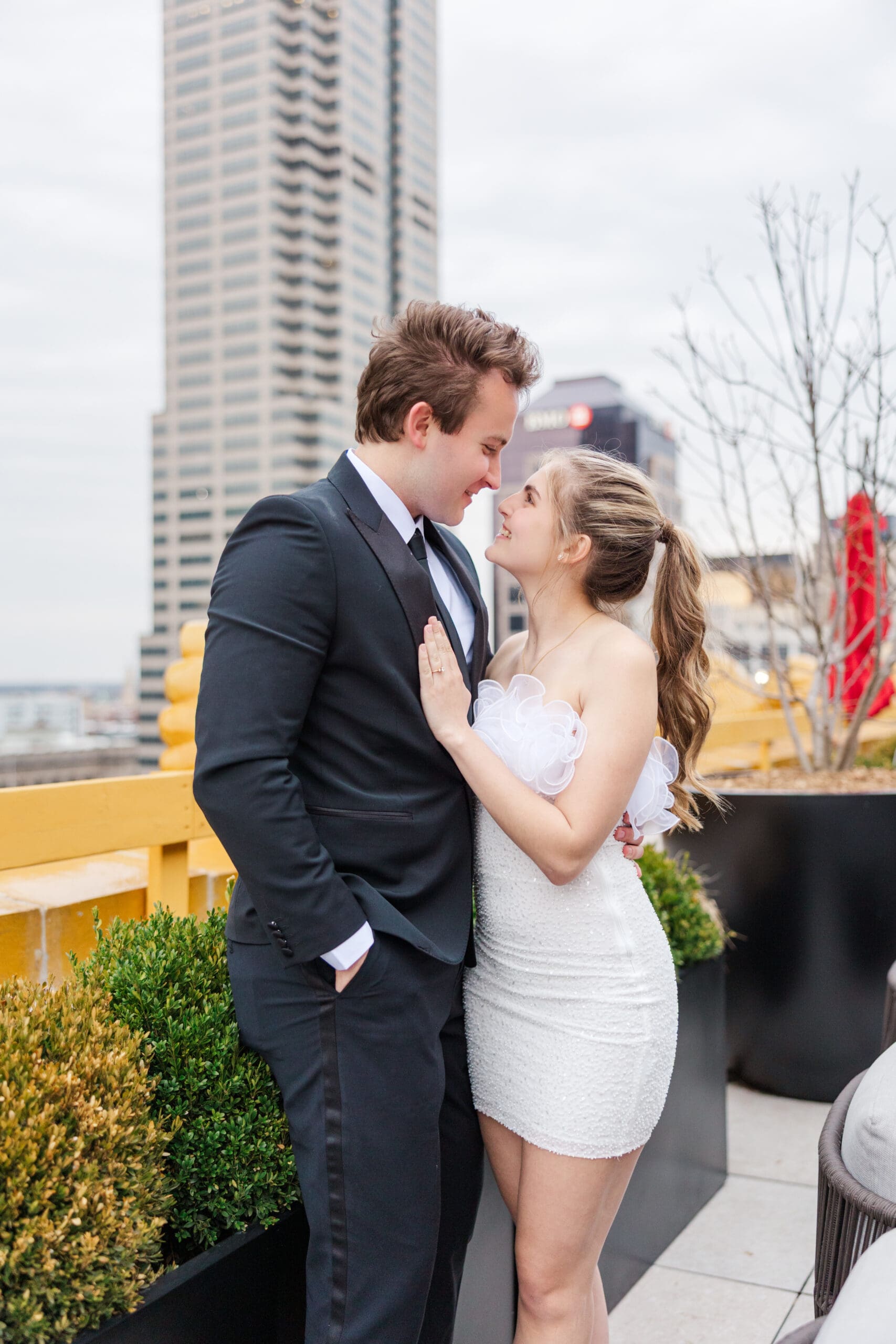 Natalie and Nathan walking together on a rooftop with sweeping city views, shot by Jordan Z Photography